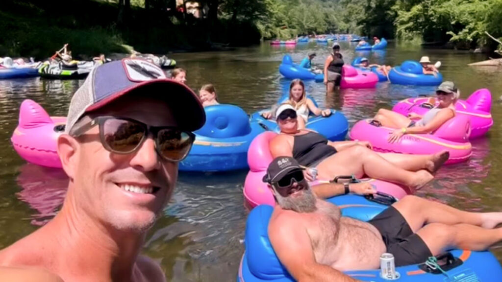 A group floats on colorful tubes with Wahoo's Adventures, smiling and enjoying a sunny day.