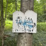 Faded white wooden sign with Cascade in blue, marking Treehouse Cabins Near Boone NC.