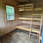 Wood-paneled room with a wooden bunk bed, like those in Treehouse Cabins Near Boone NC.
