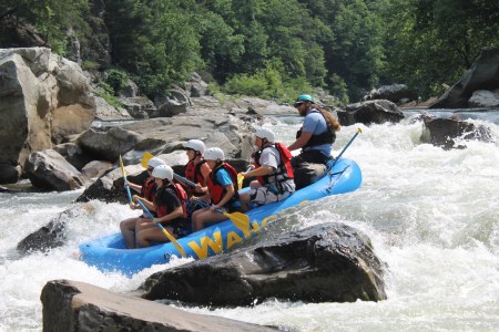 A group of people white water rafting